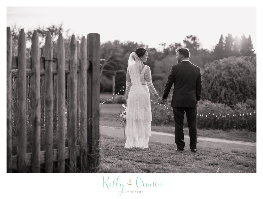 A newlywed couple take a walk, this was a Mooncussers Tavern Reception, captured by Kelly Cronin Photography