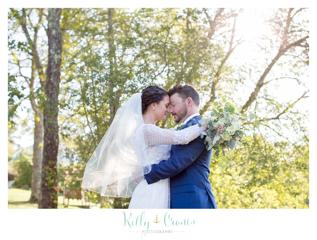A bride hugs her groom, this was a Mooncussers Tavern Reception, captured by Kelly Cronin Photography