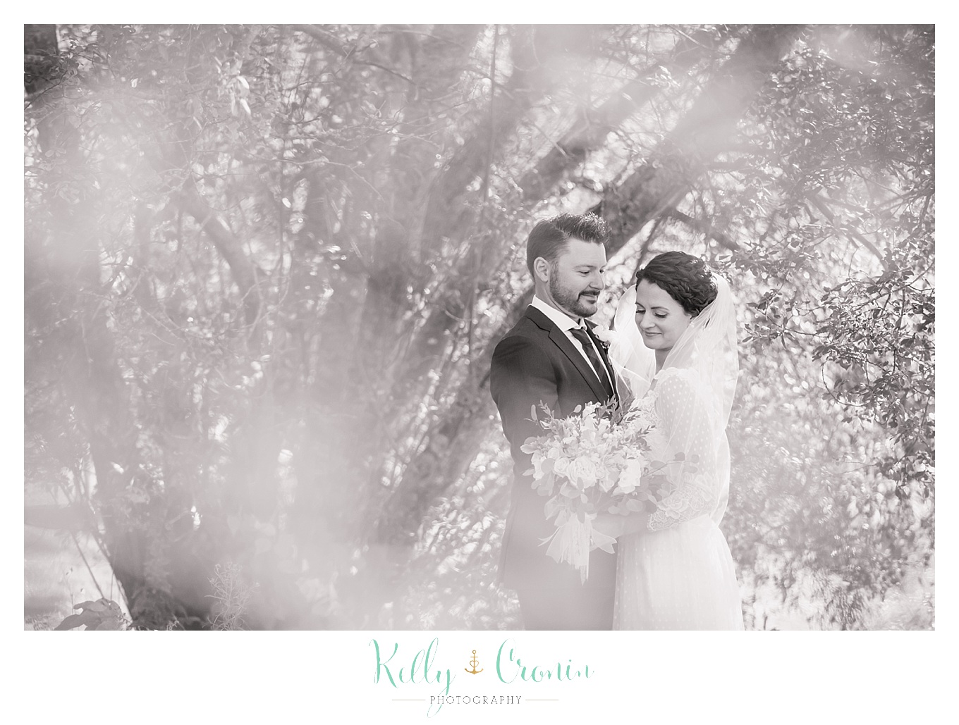 A groom holds his bride, this was a Mooncussers Tavern Reception, captured by Kelly Cronin Photography