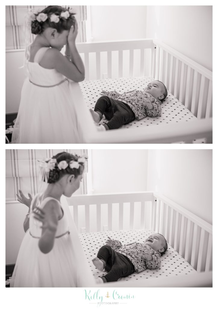 A flower girl plays with a baby, this was a Mooncussers Tavern Reception, captured by Kelly Cronin Photography