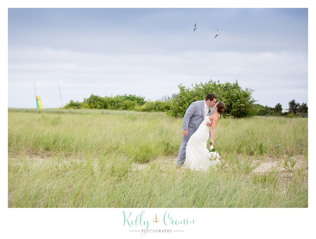 A groom dips his bride | Kelly Cronin Photography | Lighthouse Beach