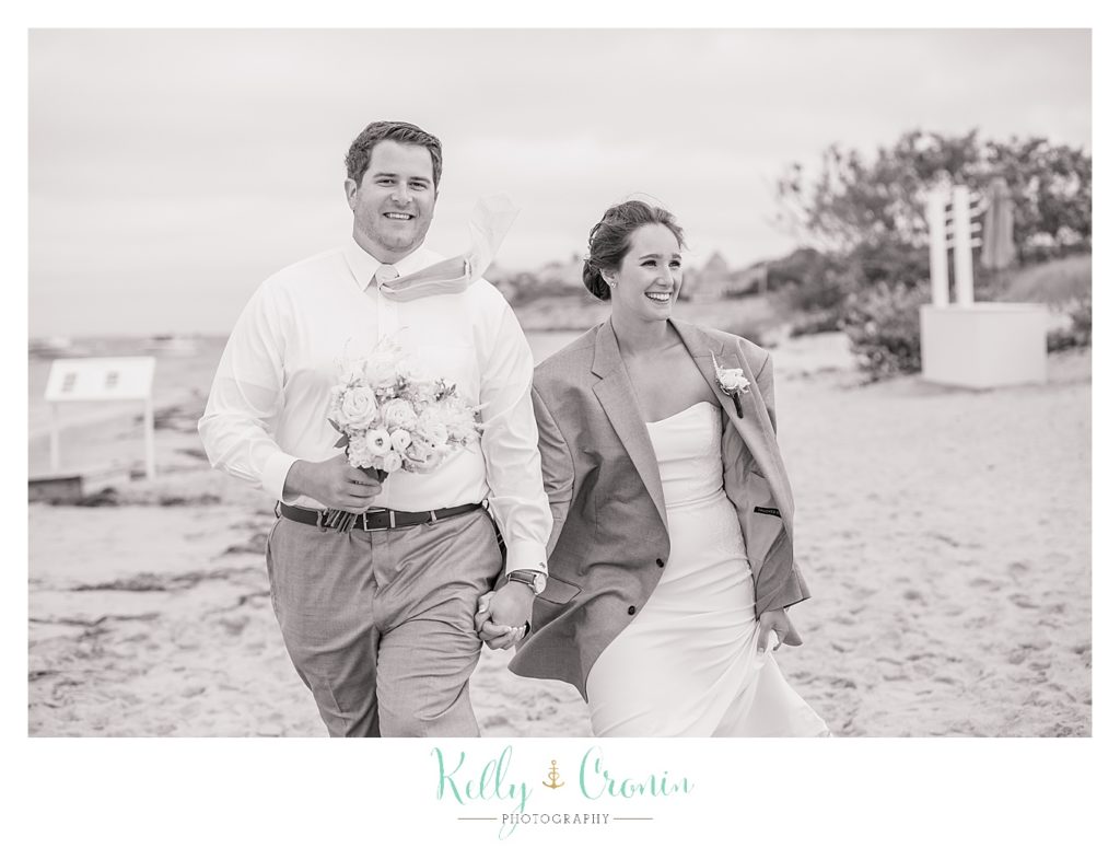 A groom lends his bride his coat | Kelly Cronin Photography | Lighthouse Beach