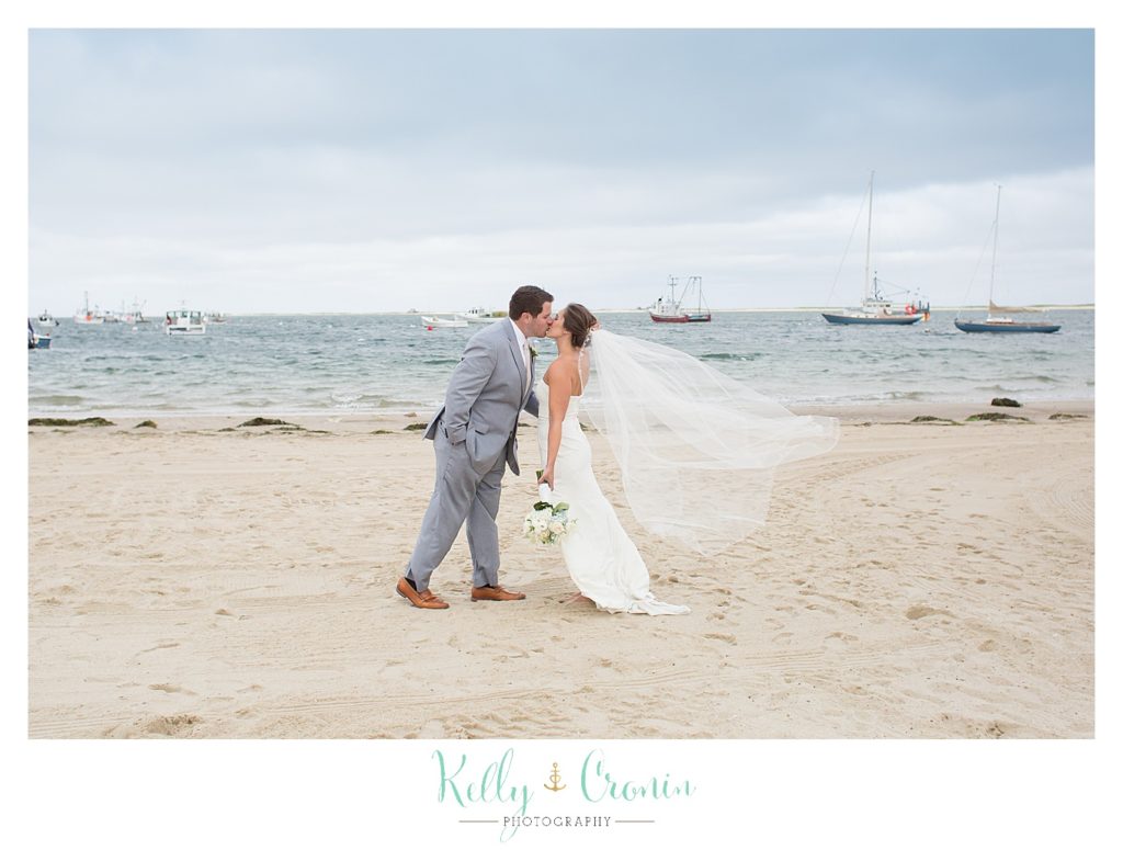 A groom leans in for a kiss | Kelly Cronin Photography | Lighthouse Beach
