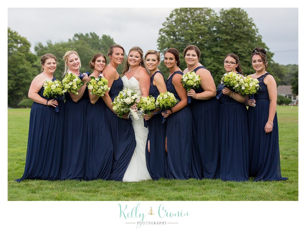 A bride poses with her bridal party | Kelly Cronin Photography | Ocean Edge Resort and Golf Club