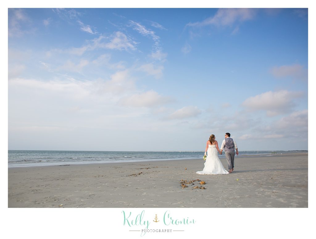 A bride and groom stand on the beach | Kelly Cronin Photography | Ocean Edge Resort and Golf Club
