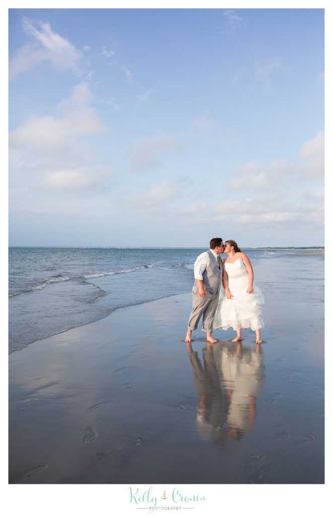 A groom kisses his bride on the beach | Kelly Cronin Photography | Ocean Edge Resort and Golf Club
