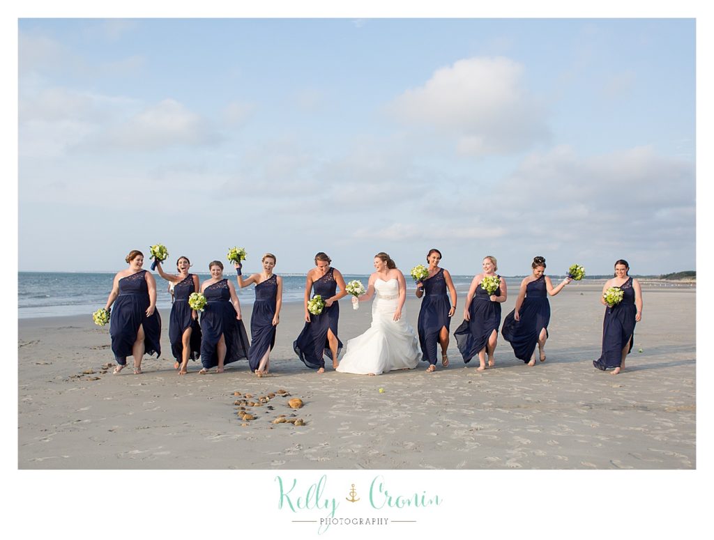 A bride and her bridal party strike a funny pose | Kelly Cronin Photography | Ocean Edge Resort and Golf Club