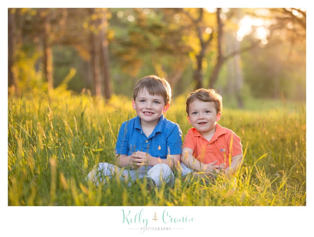 Two boys sit in the tall grass | Kelly Cronin Photography | Cape Cod Family Photographer 