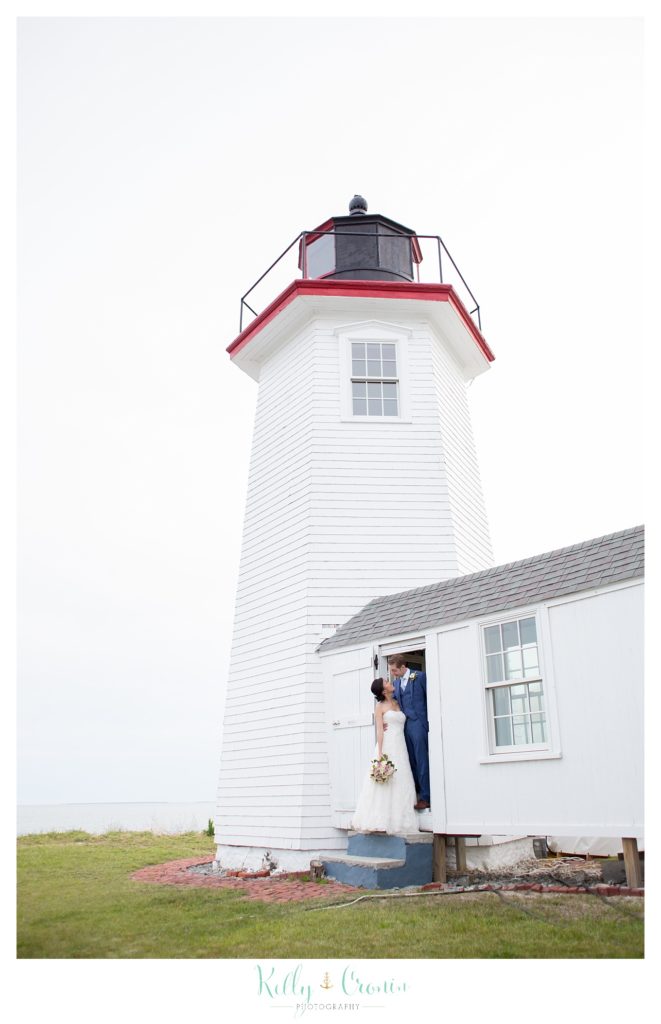 A groom kisses his love in front of a lighthouse | Kelly Cronin | Wing's Neck Light 