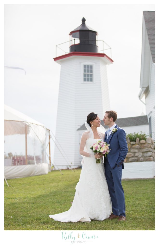 A newly married couple kiss in front of a lighthouse | Kelly Cronin | Wing's Neck Light 