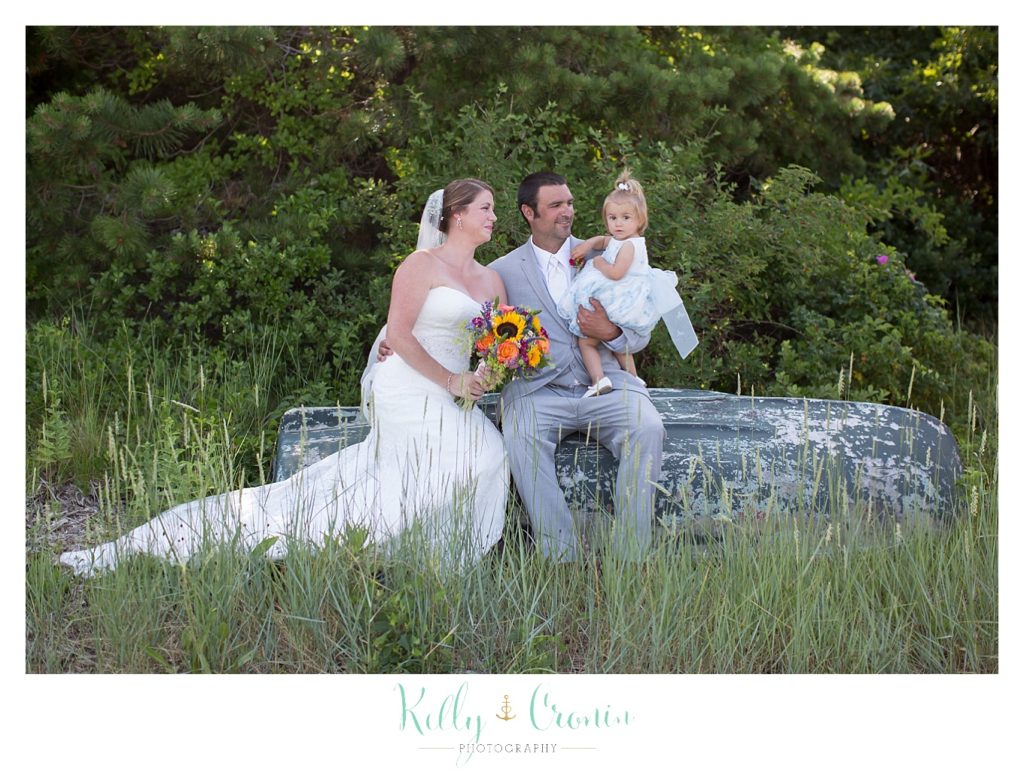 A groom holds the flower girl  | Kelly Cronin Photography | Oyster River Landing