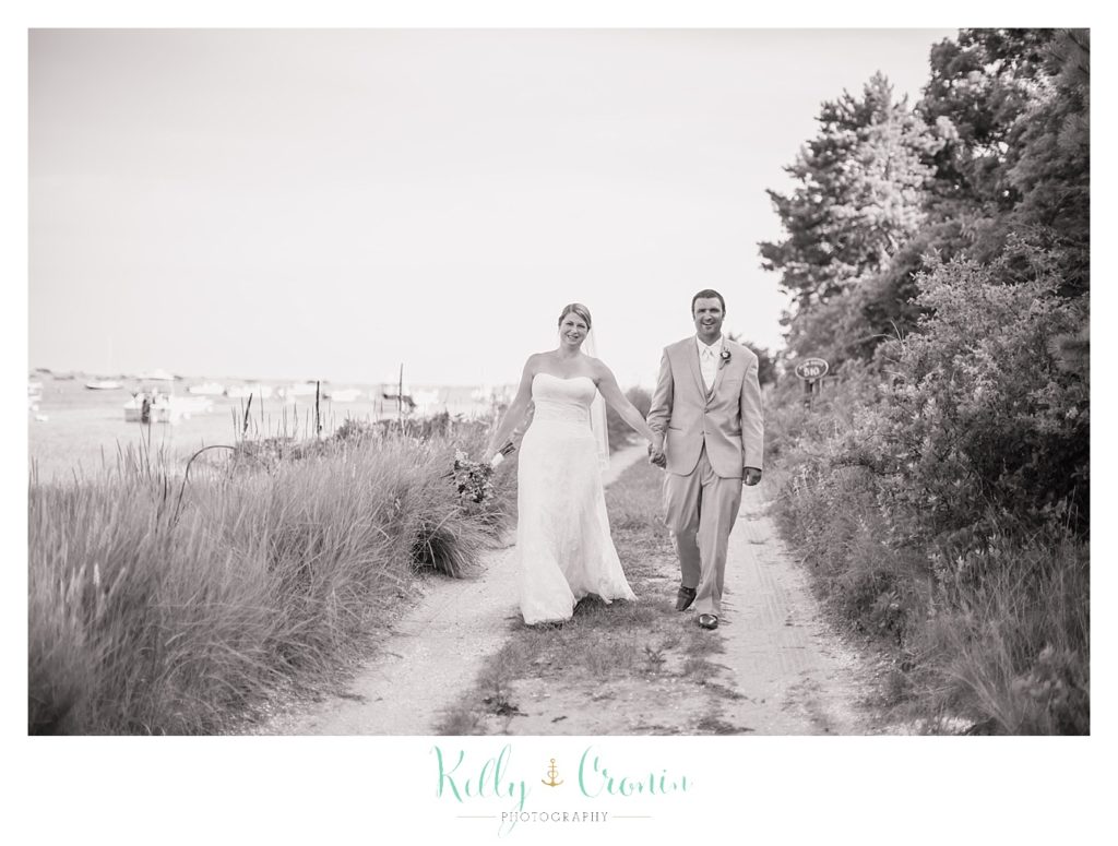 A bride and groom take a walk together  | Kelly Cronin Photography | Oyster River Landing
