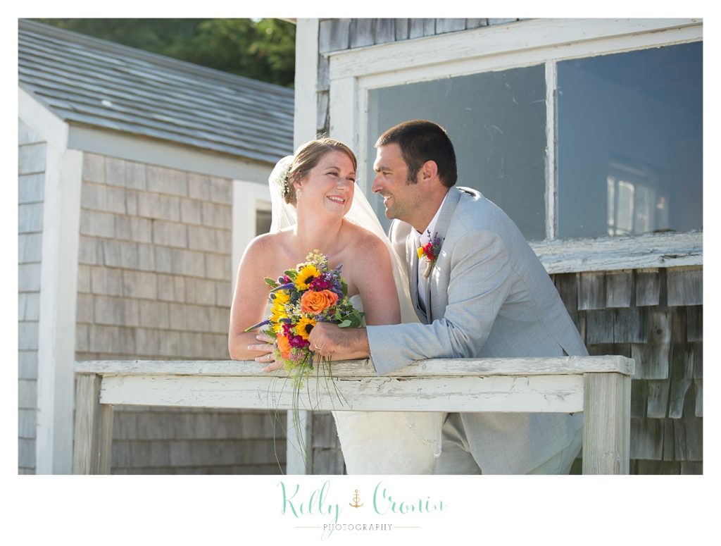 A groom leans in towards his bride  | Kelly Cronin Photography | Oyster River Landing