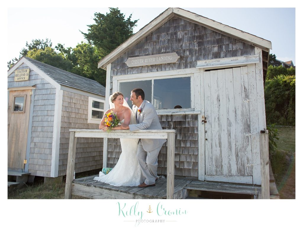 A bride leans into her groom  | Kelly Cronin Photography | Oyster River Landing