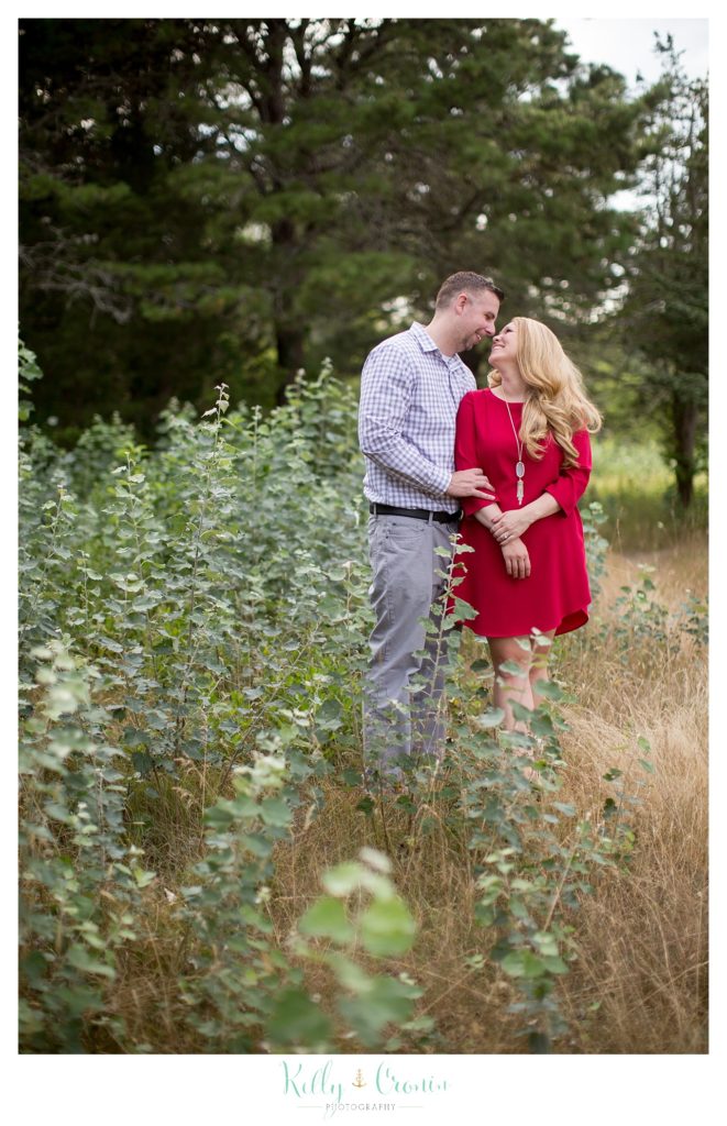 A couple walk through a field of grass  | Kelly Cronin Photography | Outdoor Engagement Session