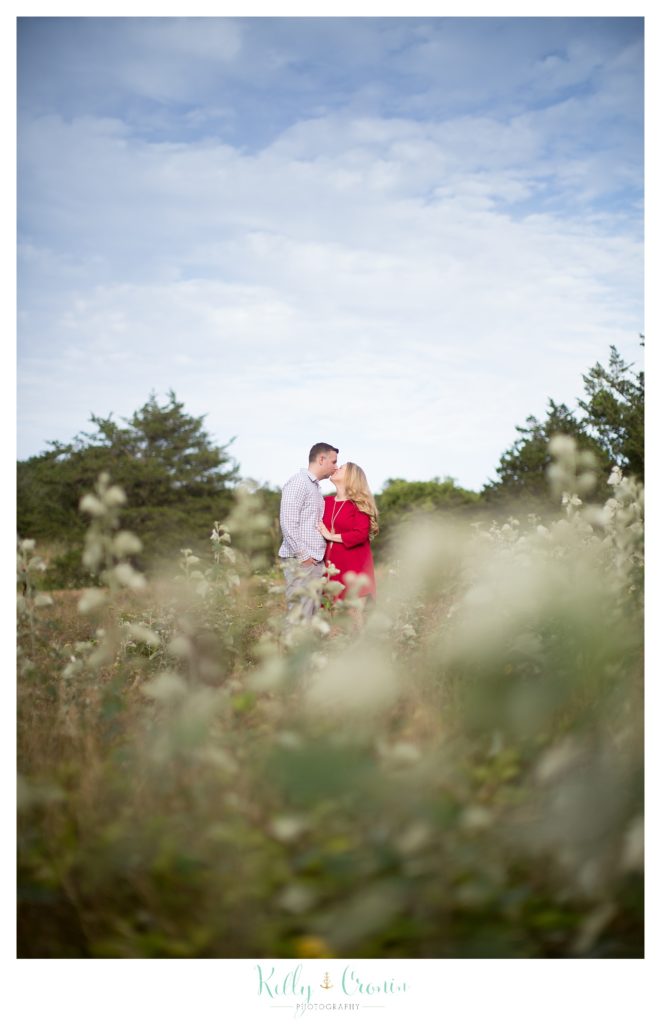 A couple sneak a kiss  | Kelly Cronin Photography | Outdoor Engagement Session