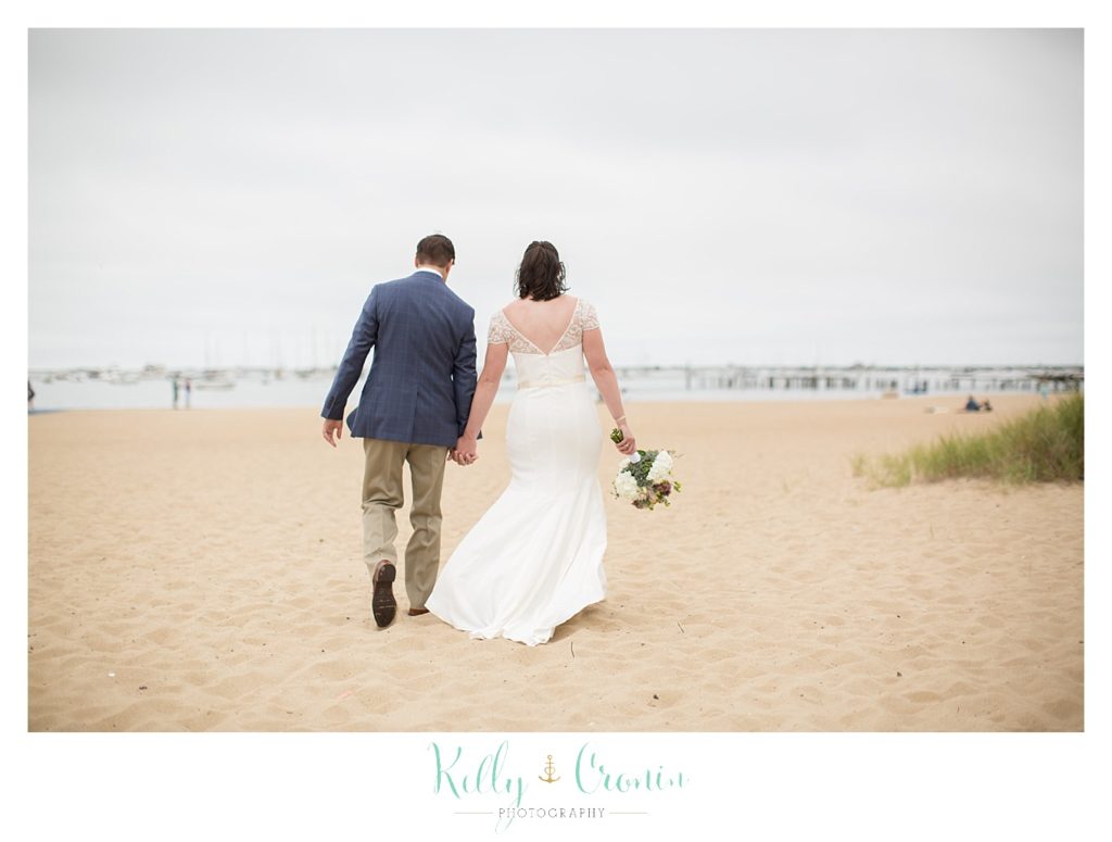 A couple walk along the beach | Kelly Cronin Photography | Pilgrim Monument