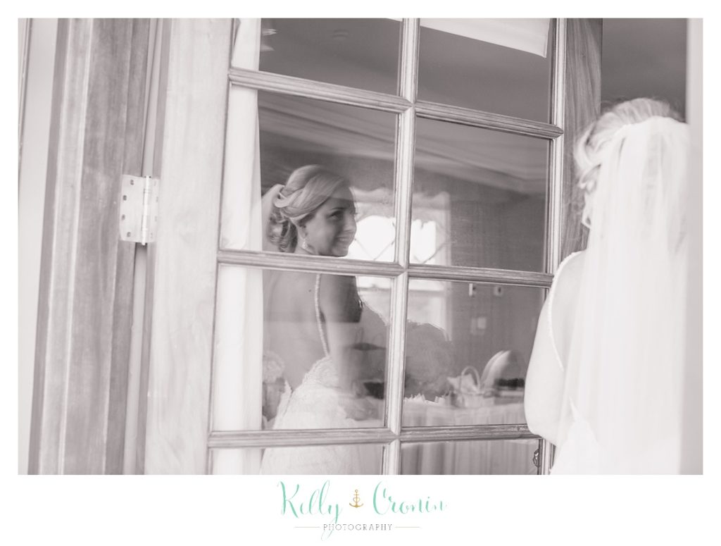 A bride looks out of a window | Kelly Cronin Photography | Resort Wedding in Cape Cod