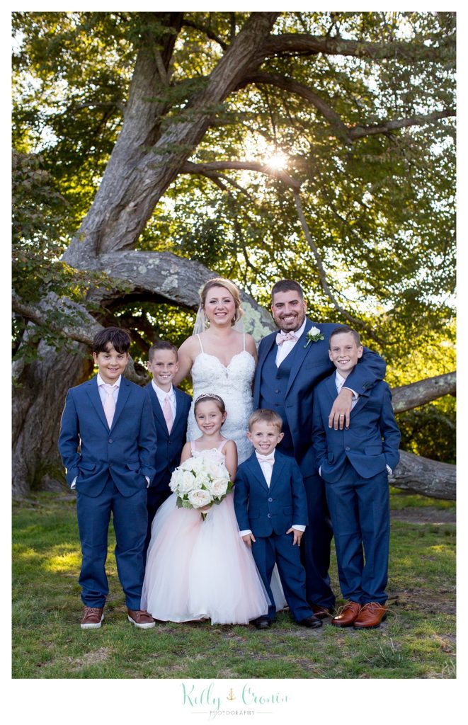 A bride and groom pose with the children in the wedding party | Kelly Cronin Photography | Resort Wedding in Cape Cod