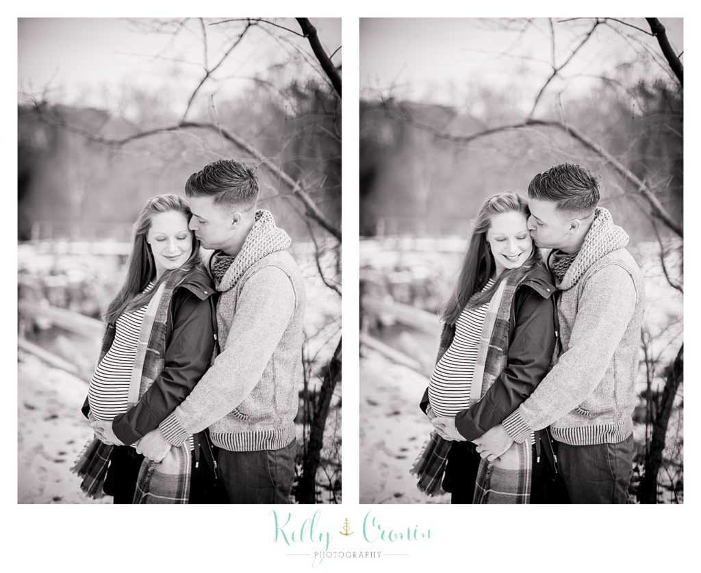 A man gives his wife a kiss  | Kelly Cronin Photography | Cape Cod Maternity Photographer