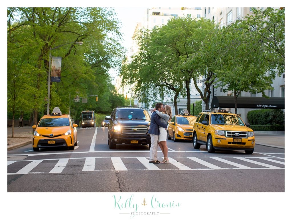 A couple kiss on a busy street  | Kelly Cronin Photography | NYC Engagement Shoot