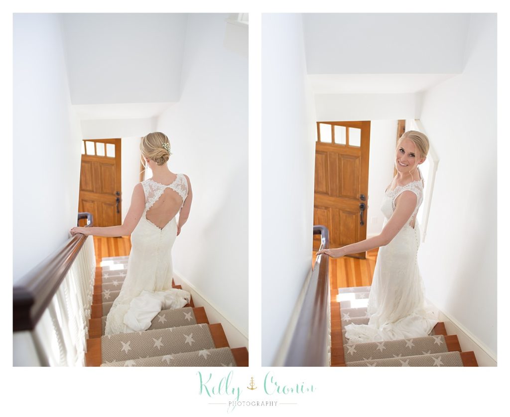 A bride walks down some stairs in her dress. 