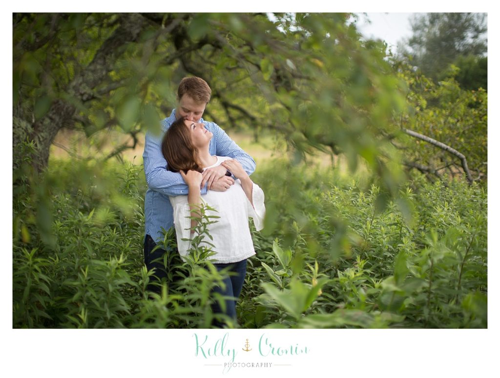 A woman leans back to look at her fiance as they stand in Thompson's Field. 