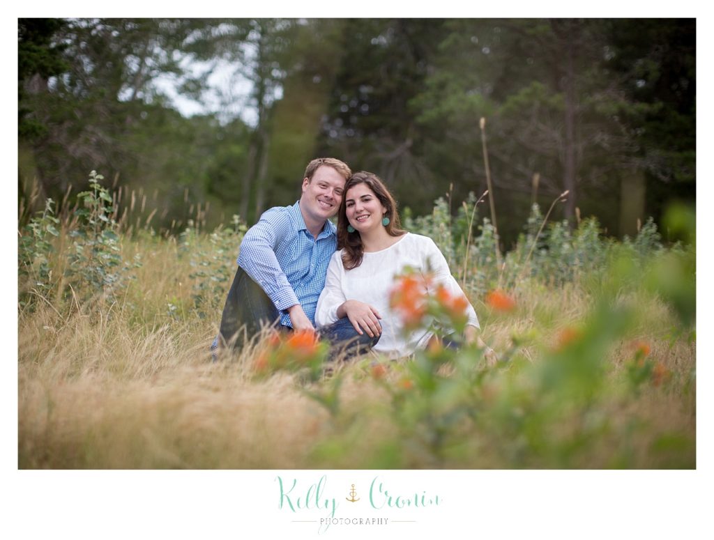 A couple sit in the grass in Thompson's Field.