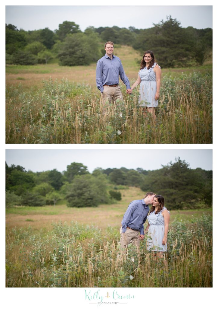 A couple walk through a field of flowers. 