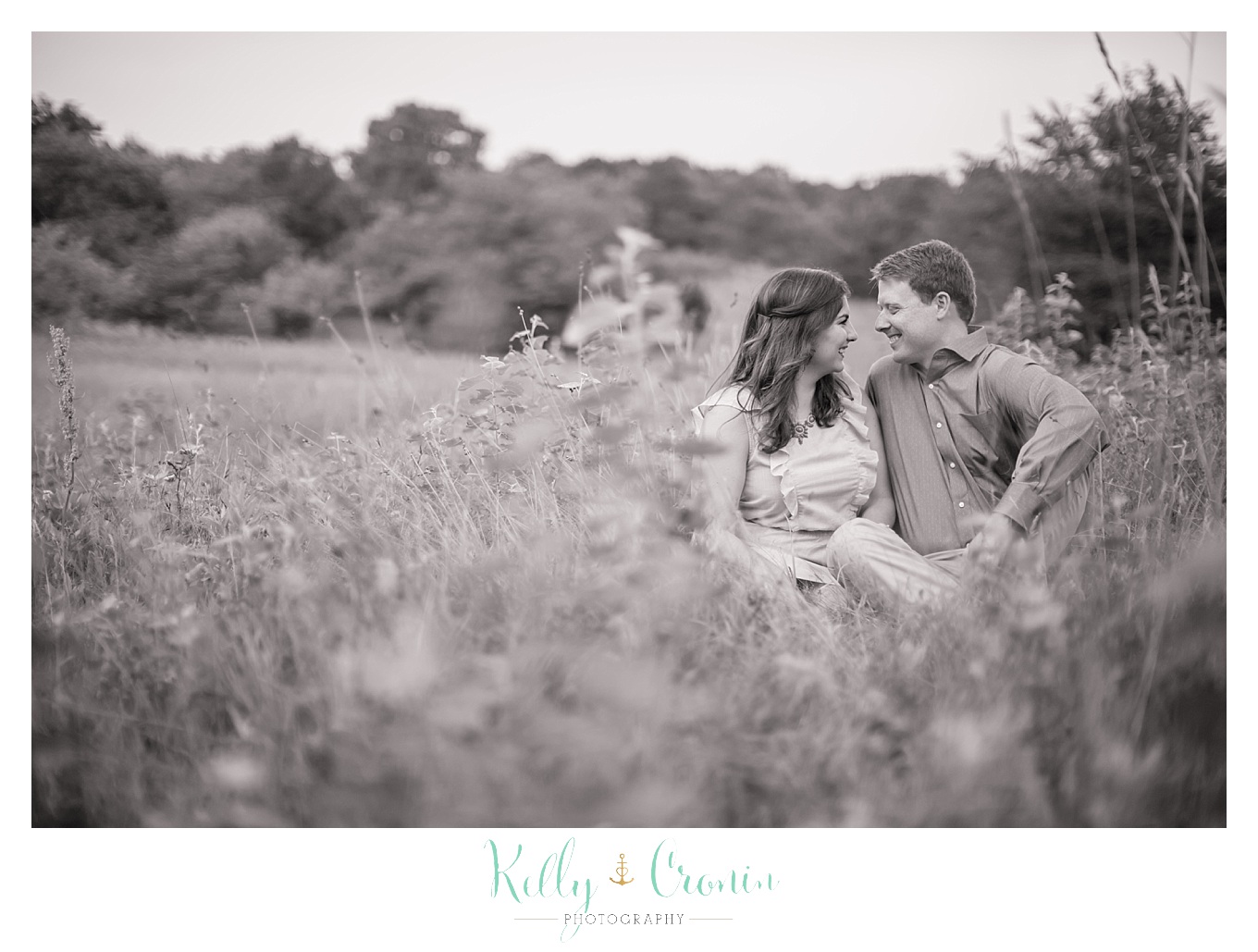 An engaged couple share an intimate moment in Thompson's Field, captured by Kelly Cronin Photography.