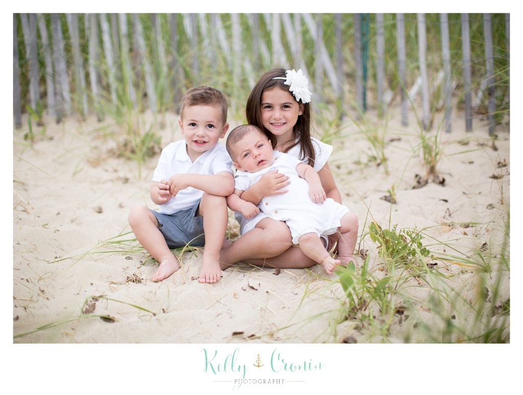 Siblings sit in the sand  | Kelly Cronin Photography | Seaside Session in Cape Cod