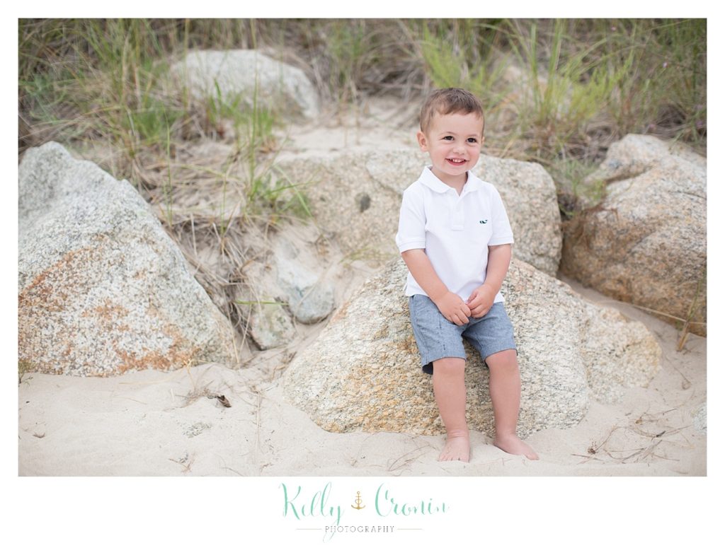 A boy sits on a rock  | Kelly Cronin Photography | Seaside Session in Cape Cod