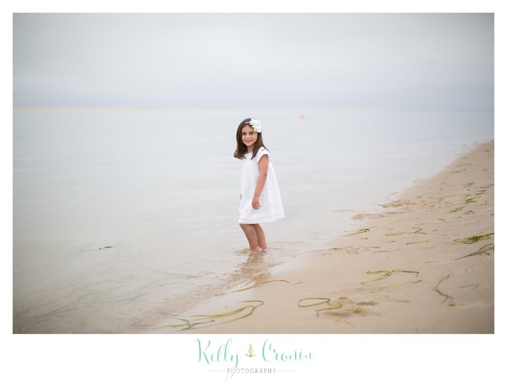 A girl dips her toes into the ocean  | Kelly Cronin Photography | Seaside Session in Cape Cod