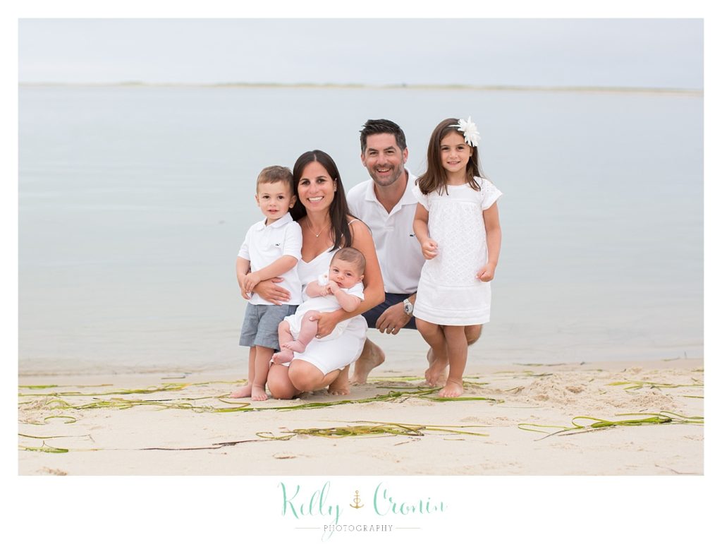A family stands on the shore  | Kelly Cronin Photography | Seaside Session in Cape Cod