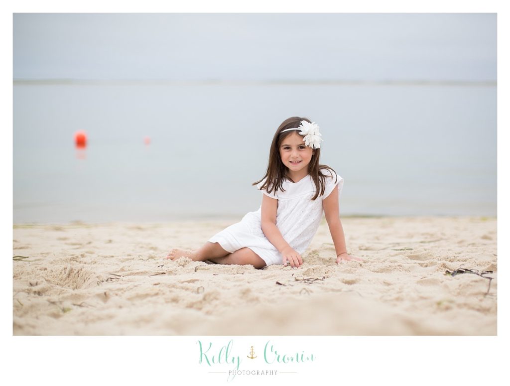 A girl digs her fingers in the sand  | Kelly Cronin Photography | Seaside Session in Cape Cod