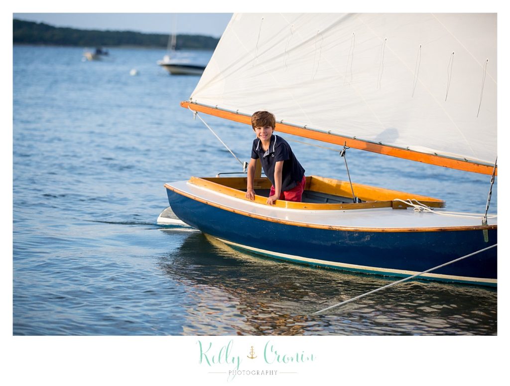 A boy sits in a sail boat