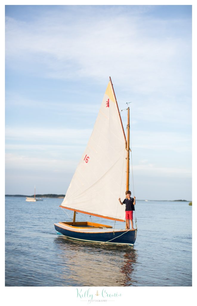 A boy stands on a sail boat