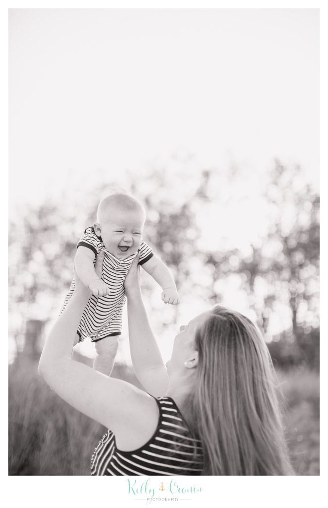 A mother holds her baby up like an airplane | Kelly Cronin Photography | Family Photography in Cape Cod