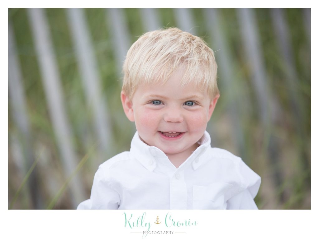 The best family photographer in Cape Cod captures a blonde boy smiling. 