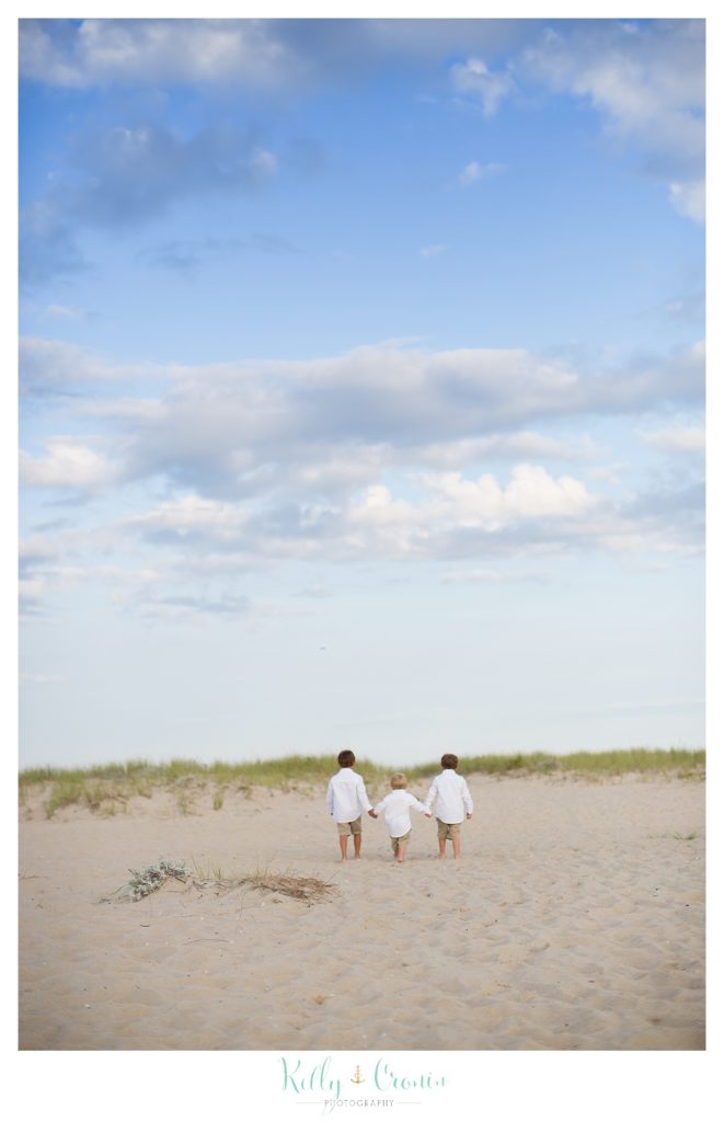 The best family photographer in Cape Cod captures three brothers walking. 