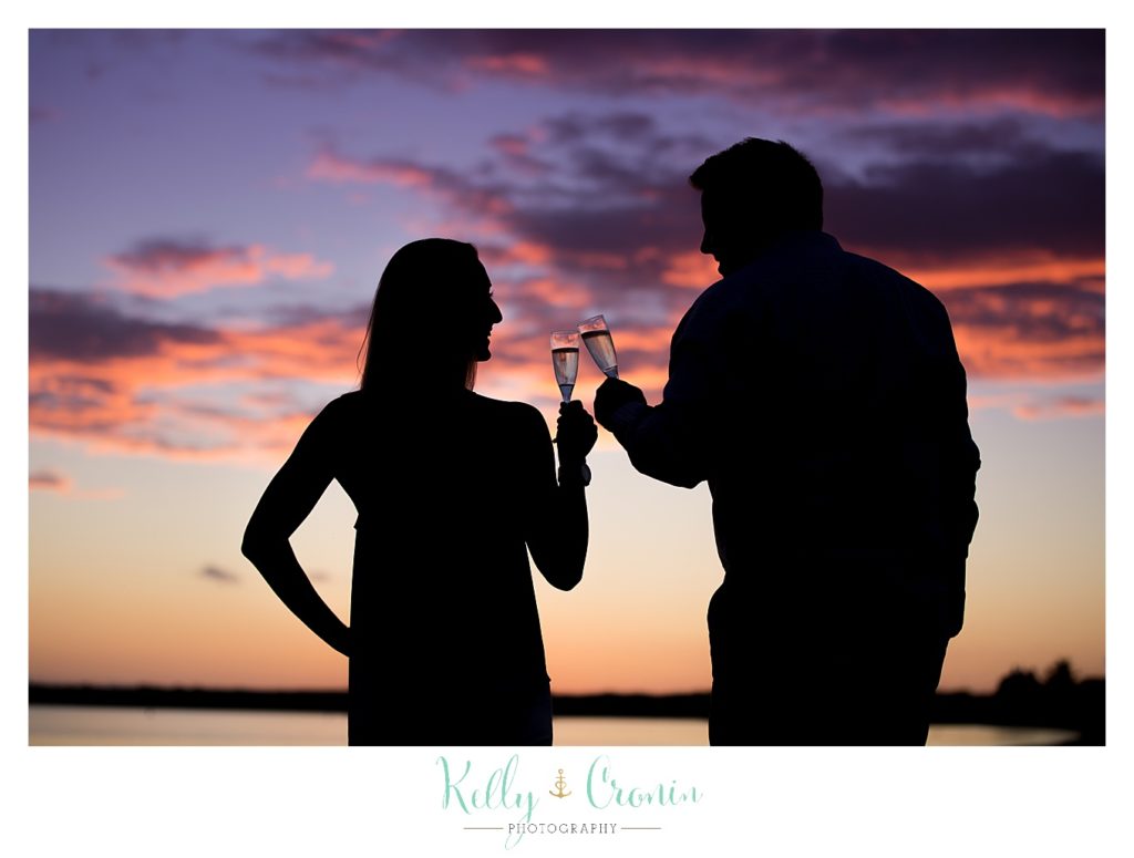A couple enjoy some champagne on the beach.  