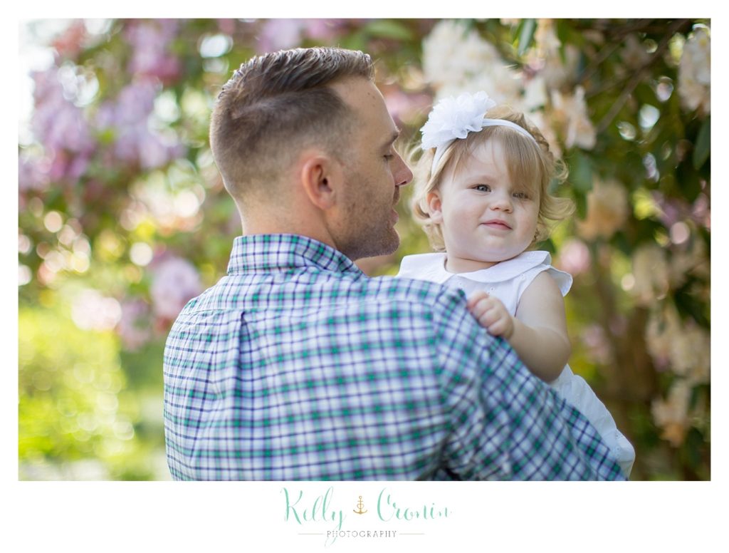 A father holds his daughter for some family mini sessions. 