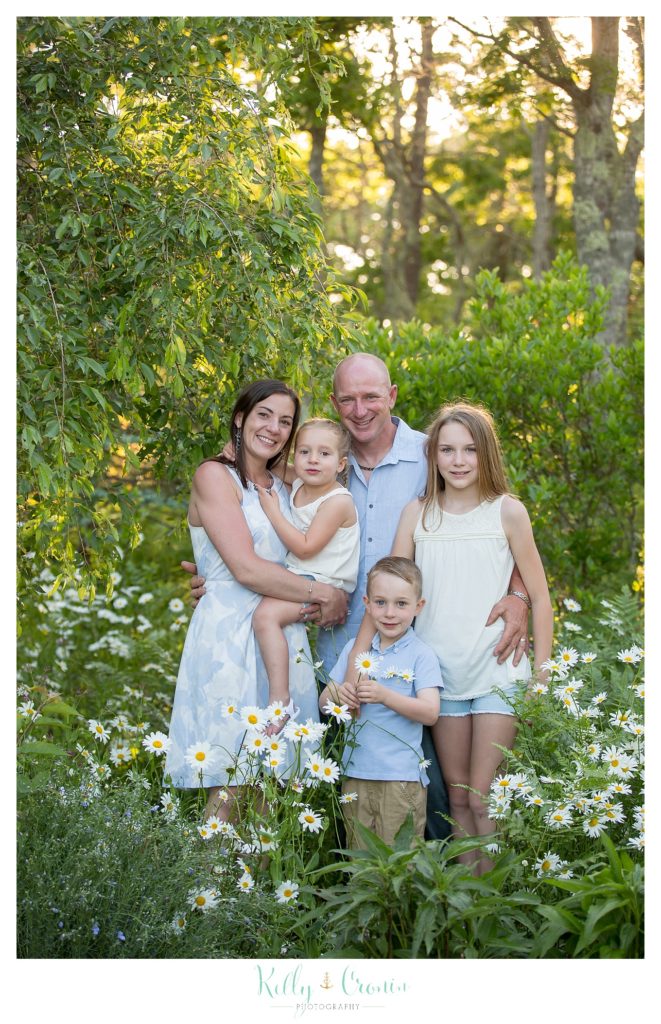A family stands among flowers | Family Photographer In Cape Cod 
