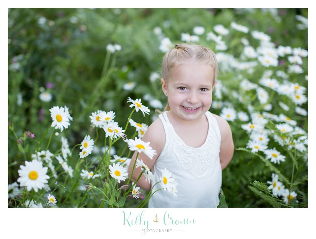 A little girl holds her hands behind her back | Family Photographer In Cape Cod 
