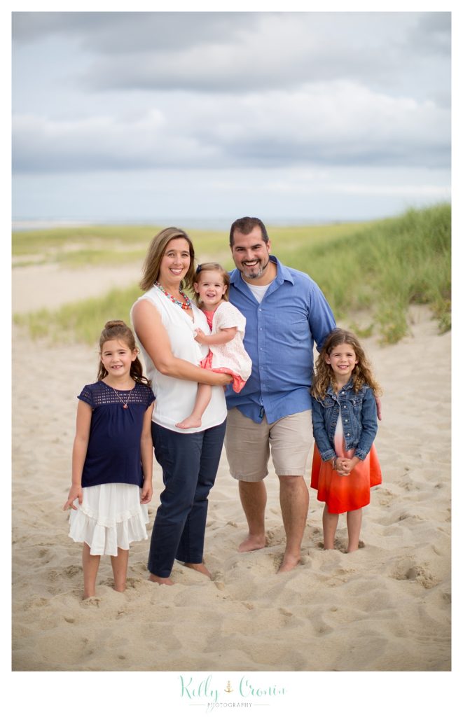A family huddles on the beach together for their Family Photography Session