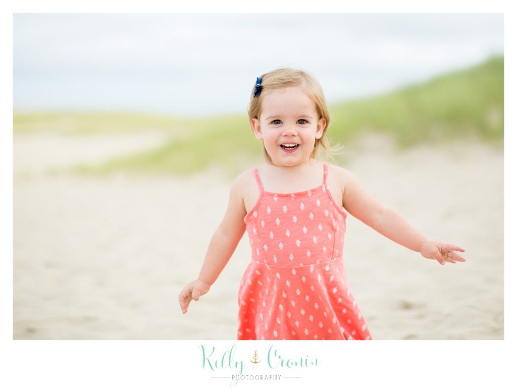 A little girl runs on the beach. 