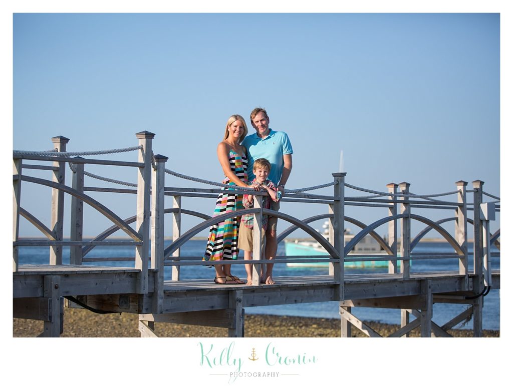 A family stands on a bridge. 