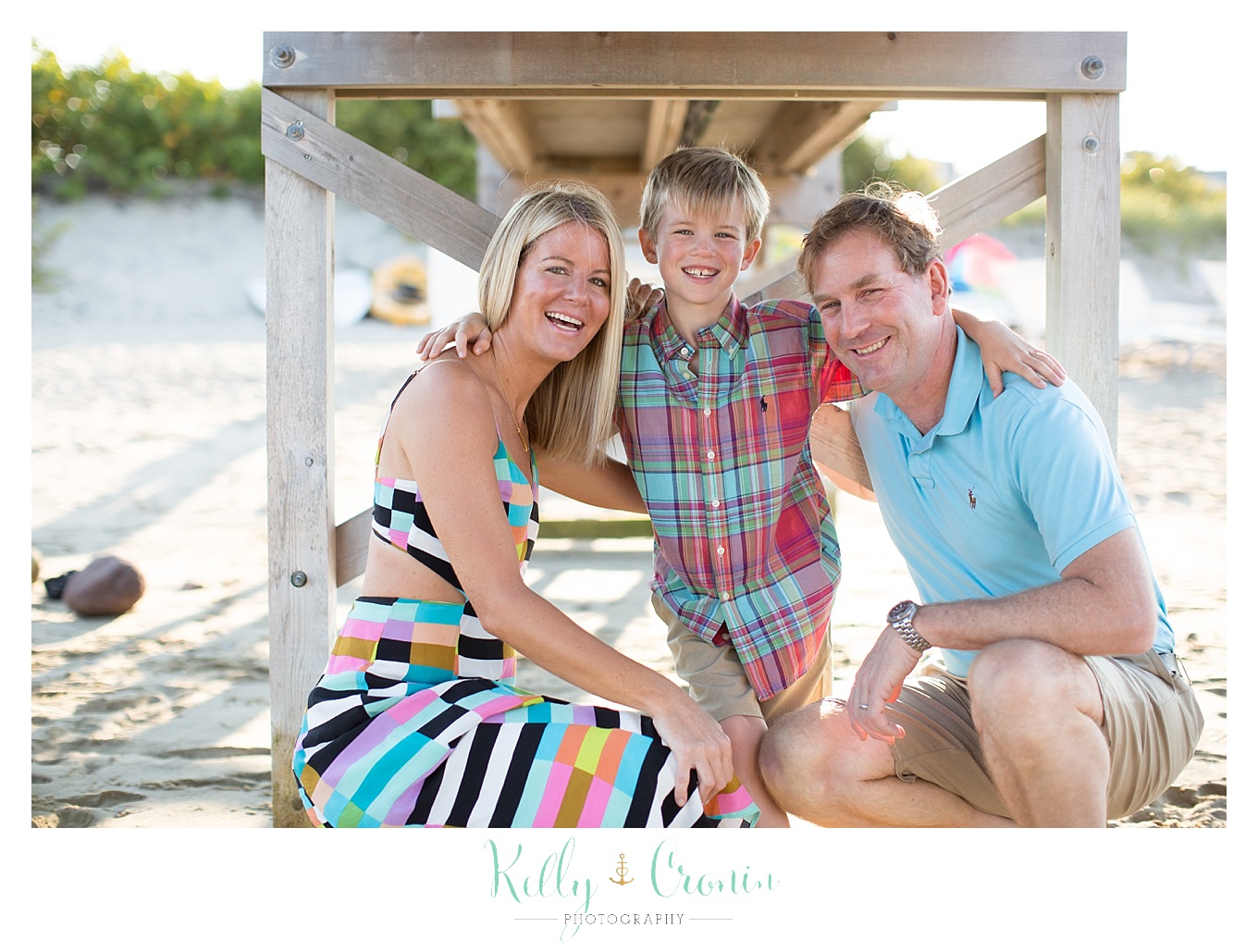 A family of three huddles close together under a bridge.
