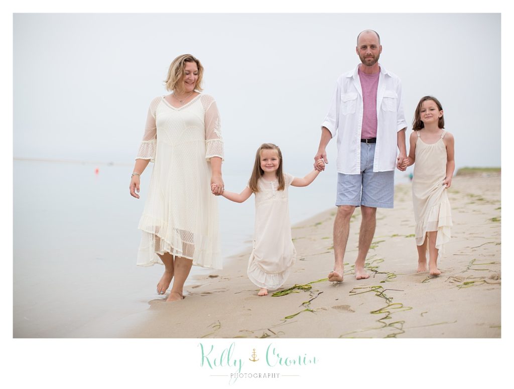 A family stands in a line holding hands | Family Photographer In The Cape