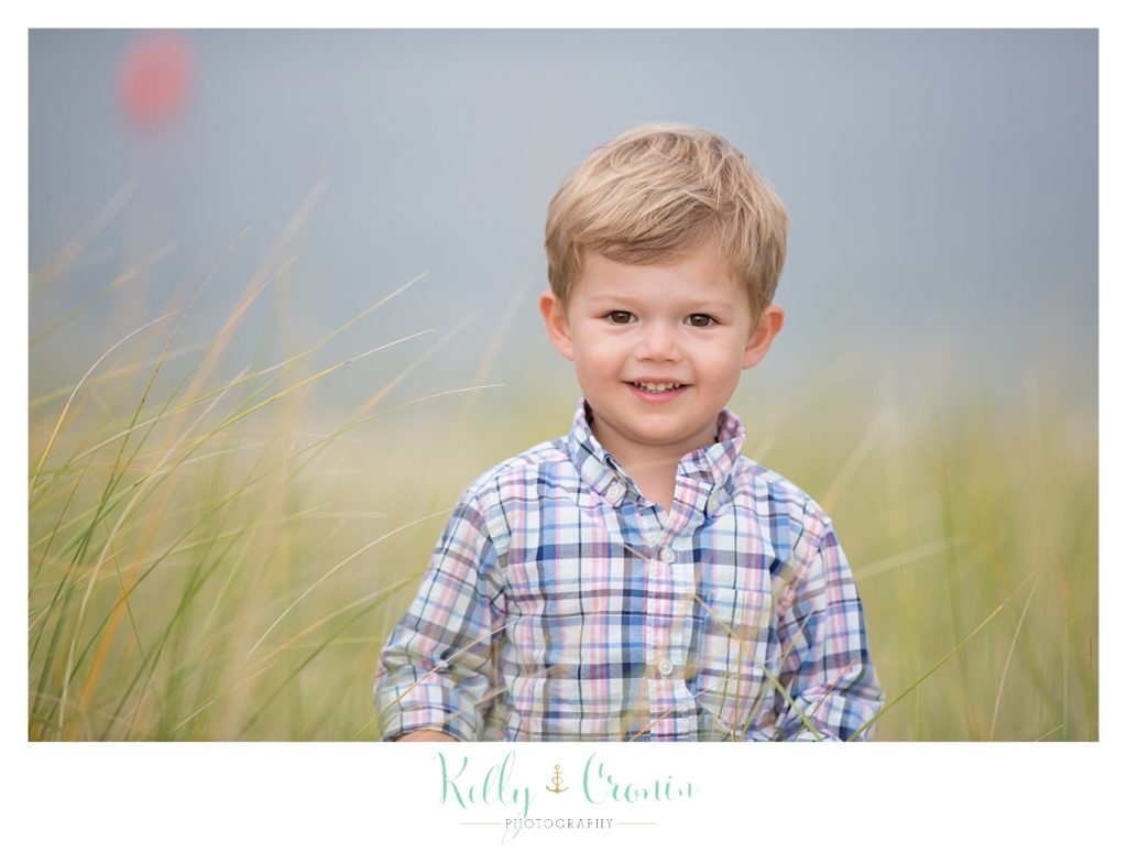 A boy gives a cute smile during his family photographs in Cape Cod. 